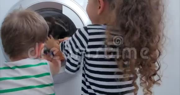 可爱的孩子们看着洗衣机里面气缸旋压机工业概念洗衣机视频的预览图