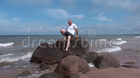 在海边的石头上受伤的人视频的预览图