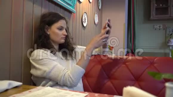 美丽令人兴奋的年轻女人在咖啡馆自拍视频的预览图