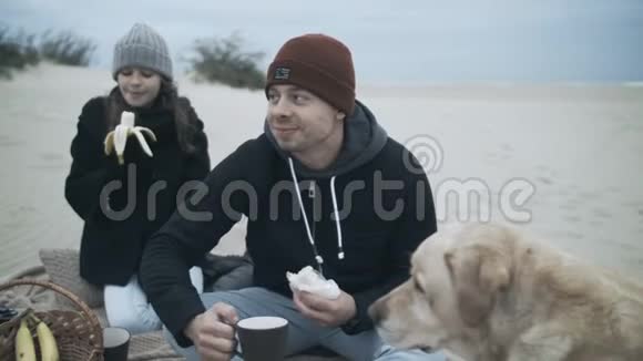 可爱的家人安排了一顿野餐丈夫妻子和孩子和一只狗在海滩上度假视频的预览图