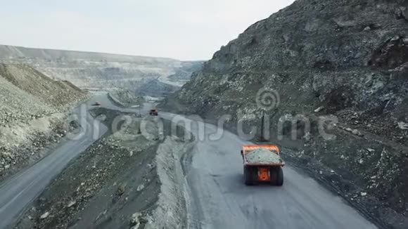 采石场自卸卡车俯视图自卸卡车行驶在布满灰尘的露天采矿道路上重型运输视频的预览图