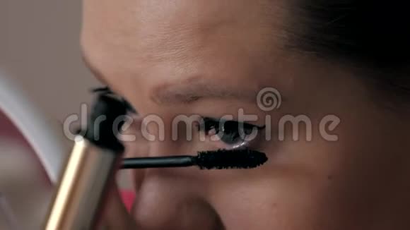 美丽的白种人女孩用大刷子染睫毛时尚界化妆品视频的预览图