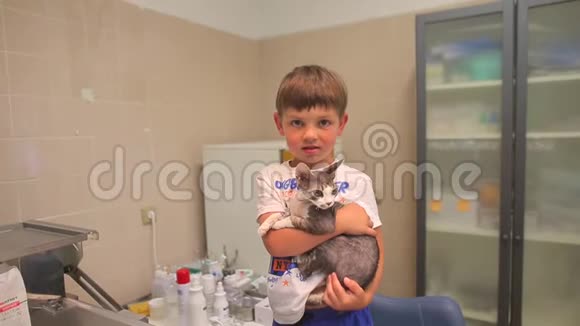 孩子在兽医诊所里手里拿着一只小猫视频的预览图