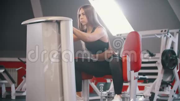 一位在健身房训练的女运动员在蝴蝶训练装置上锻炼视频的预览图