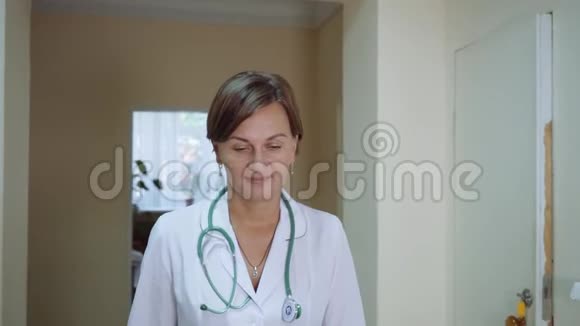一位女医生走在综合医院的走廊上慢动作特写镜头视频的预览图