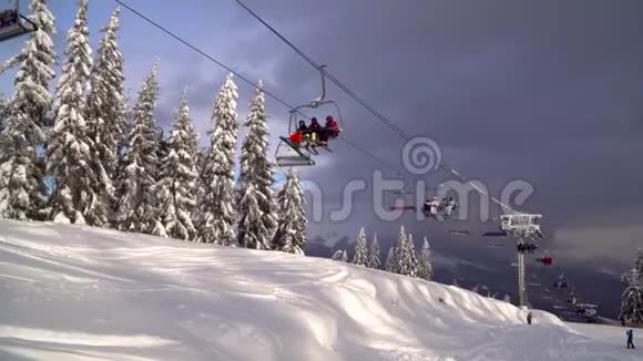 滑雪电梯载着滑雪者和滑雪板在山上视频的预览图