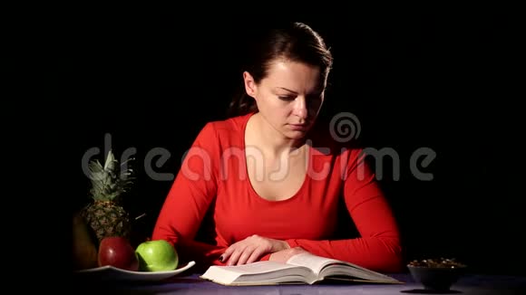 一个女孩在桌旁看书喝酒视频的预览图