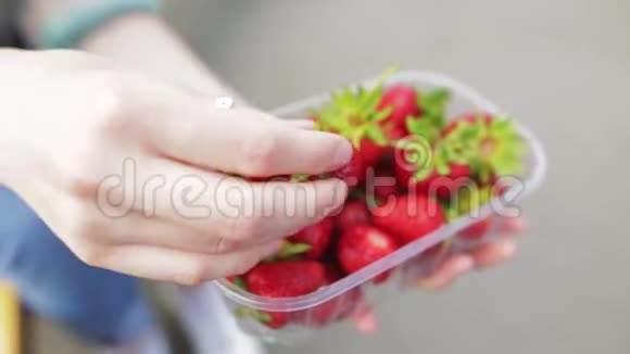 年轻女孩的生食展示了一些有机草莓的浆果视频的预览图