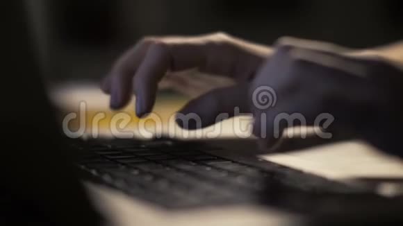 女性手在黑暗内部的现代笔记本电脑上打字视频的预览图