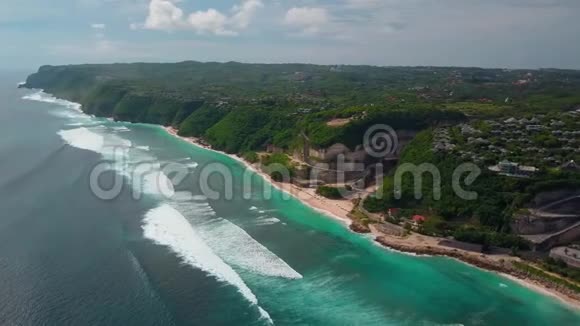 鸟瞰热带海滩绿松石海浪绿色别墅景观视频的预览图