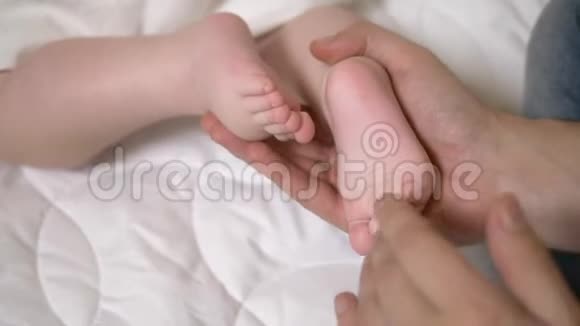 男性的手在婴儿的腿上做按摩视频的预览图