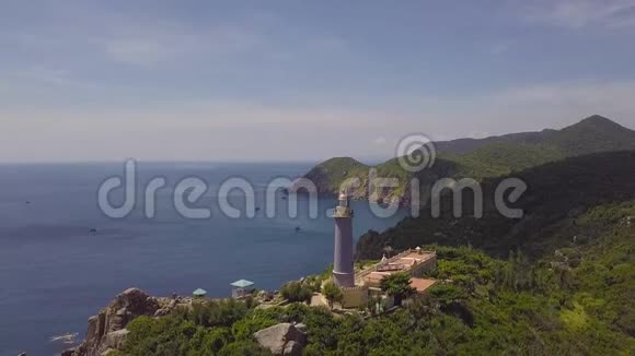 雄蜂在清澈的地平线上俯瞰青山碧海的灯塔山崖海景灯塔视频的预览图
