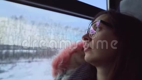 戴眼镜的年轻女子在冬天乘火车旅行视频的预览图