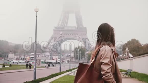 年轻快乐的女人走在巴黎埃菲尔铁塔附近法国游客环顾四周微笑着慢动作视频的预览图