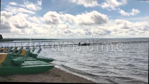 淡水湖天气晴朗波浪上有岩石船和在蓝天上郁郁葱葱的云彩视频的预览图
