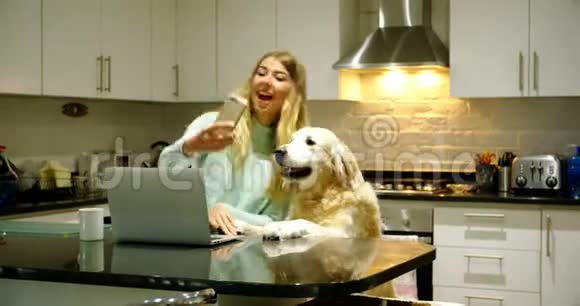 女人和她的狗在厨房自拍视频的预览图