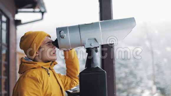 年轻人通过望远镜或望远镜在雪山上寻找旅游自然徒步旅行视频的预览图