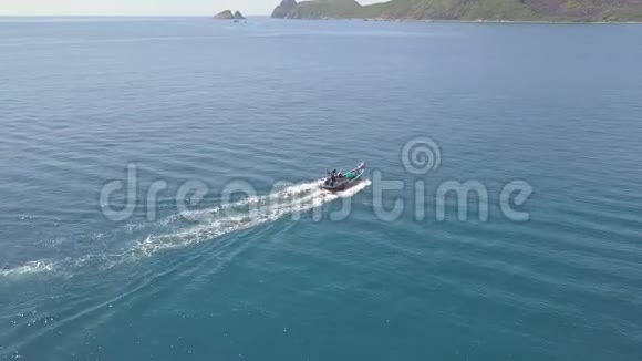 在岩石悬崖景观上的蓝色水中航行的海船在海洋中的航空视野帆船在船上飞行的机器人视频的预览图