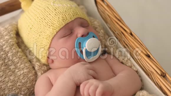 戴着针织帽子的可爱新生婴儿睡在一个有假人的摇篮里视频的预览图