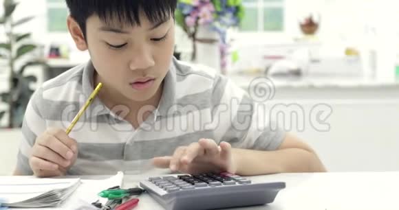 亚洲孩子读书计算和写作在家做作业视频的预览图