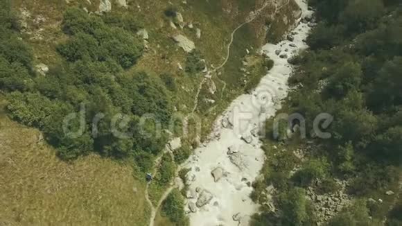 鸟瞰游客沿快速河流在山上旅行爬山视频的预览图