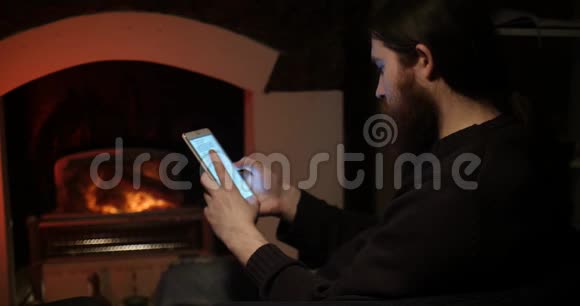 一个长胡子的男人在壁炉附近的智能手机上说话视频的预览图