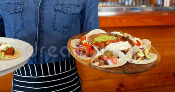 服务员拿着一盘墨西哥食品在酒吧4k视频的预览图