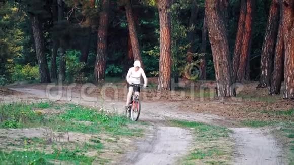女人骑着自行车穿过森林视频的预览图