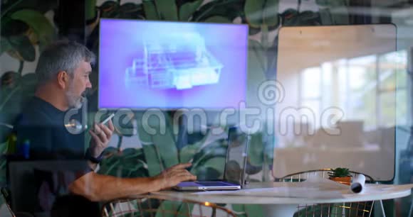 行政人员在4k会议室使用笔记本电脑时使用手机视频的预览图