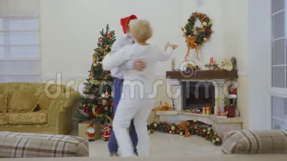 老两口在家中圣诞树附近跳舞视频的预览图