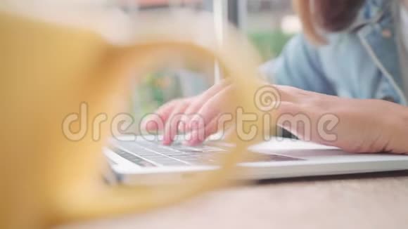 商业自由职业的亚洲女性工作在笔记本电脑上做项目在咖啡馆里坐在桌子上喝着温暖的咖啡视频的预览图