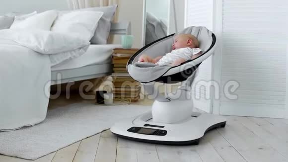 婴儿睡在白色卧室的儿童高科技设计摇椅上视频的预览图