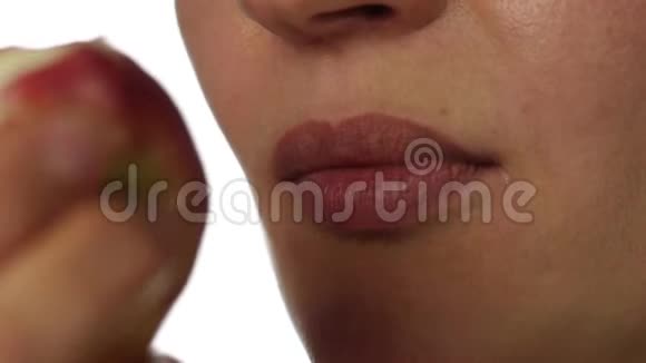 健康的女人吃白色背景的红苹果特写嘴唇健康食品和节食理念慢动作视频的预览图