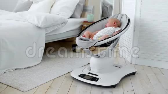 婴儿睡在白色卧室的儿童高科技设计摇椅上视频的预览图