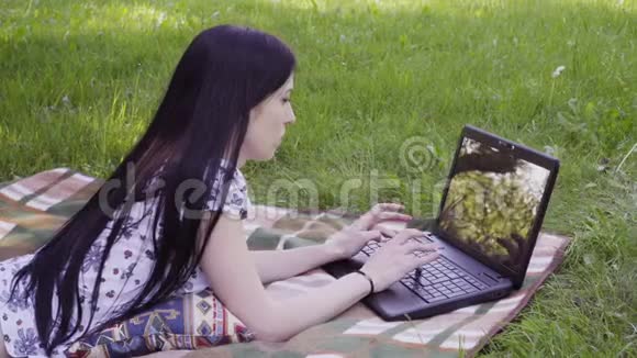 在公园里用笔记本电脑的女人视频的预览图