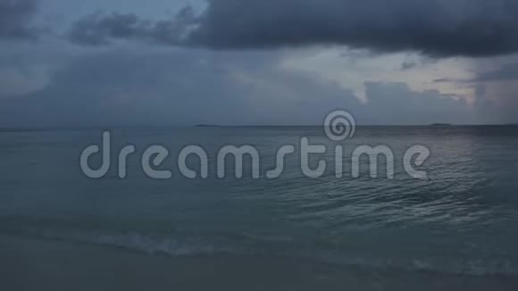马尔代夫印度洋上美丽的日落蓝色平静的水面和白色灰色的背景云几艘船很远视频的预览图