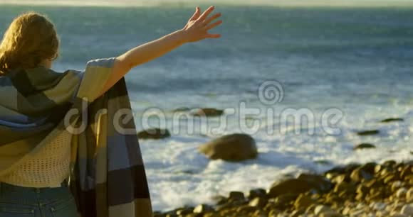 女人站在海边双臂张开视频的预览图