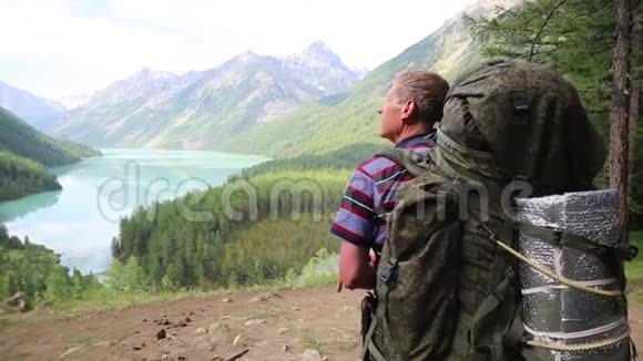 一个带着一个巨大背包的游客看着湖视频的预览图