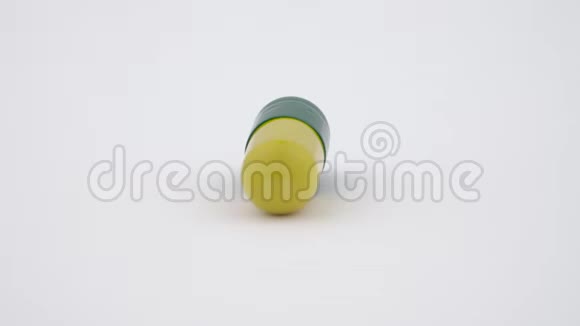 一个硬淀粉胶囊旋转在转盘上黄色和绿色孤立在白色背景上关闭宏视频的预览图