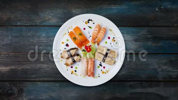 旋转生鱼片设置在白色的圆形盘子上装饰有小花日本菜俯视木制背景视频的预览图