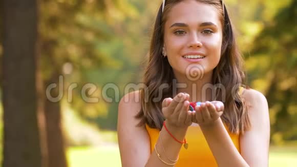 少年女孩在公园里用手吹纸屑视频的预览图