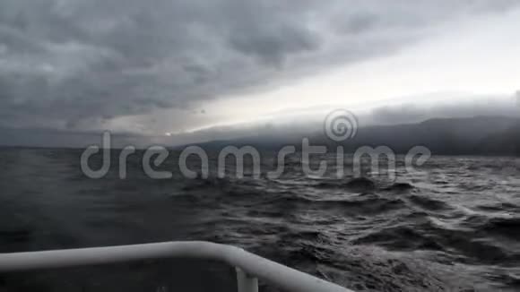 游艇上的背景是天空中的深灰色云和贝加尔湖上的风暴视频的预览图