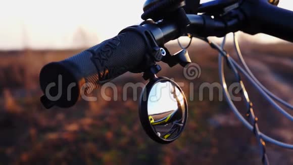 关闭自行车的部分自行车车把与镜子日落时骑自行车视频的预览图