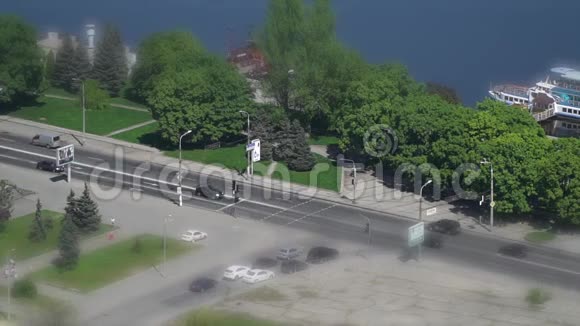 河边公共花园和汽车冲过的道路旁的倾斜移位拍摄视频的预览图