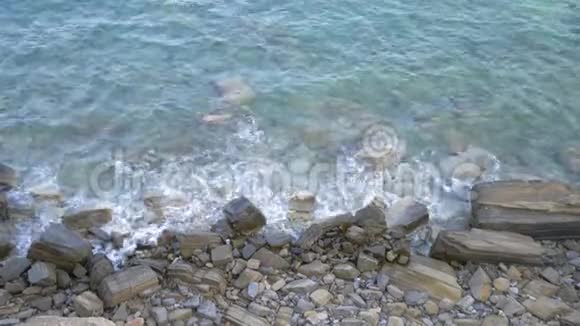 风暴海海浪拍打在海岸上的岩石近岸的海浪波浪沿着岩石海岸流动放松一下视频的预览图