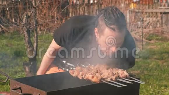 毛骨悚然的年轻人在后院的炭火烤架上烤沙什利克肉视频的预览图