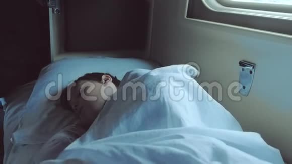 男孩晚上睡在火车的车里视频的预览图