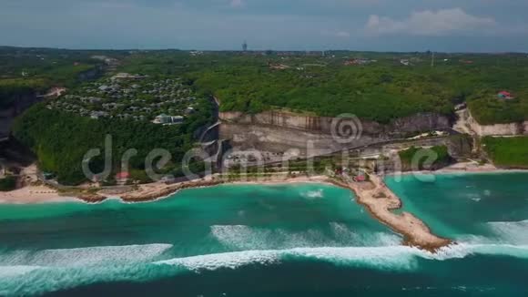 鸟瞰热带海滩绿松石海浪绿色别墅景观视频的预览图
