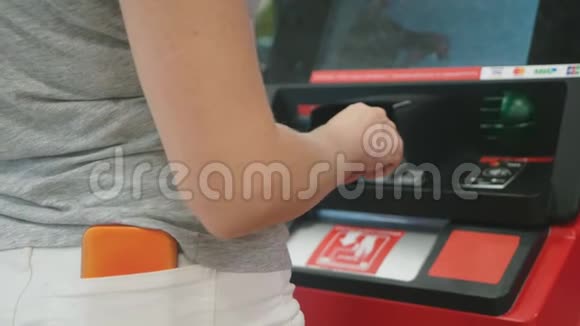 女士在自动取款机上插入一张信用卡模糊4k慢动作视频的预览图