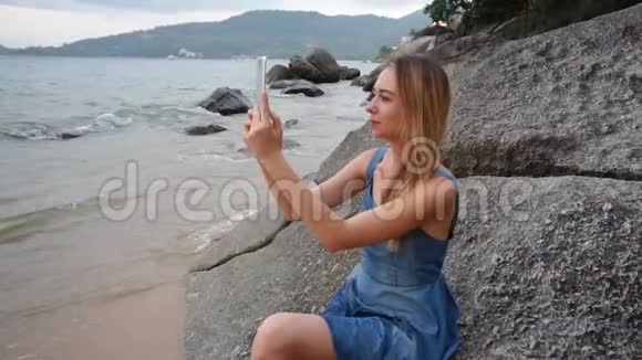 慢动作旅行女孩使用平板电脑拍摄视频海边视频的预览图